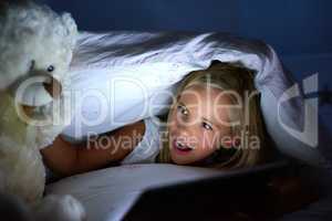 Its not just a teddy, its a dear friend. a little girl playing with her teddybear under a blanket fort at home.