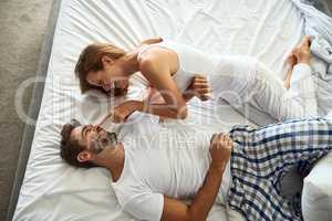 Fill your mornings with love. a happy young couple having a playful moment in bed.