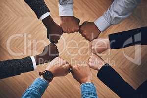 Great power stems from unity. High angle shot of a group of unidentifiable businesspeople joining their hands together in a unity.