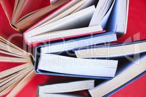 Books, education and learning for knowledge, scholarship or research with red background. Studying, reading and college lifestyle with art or library book, fiction and literature in a creative studio