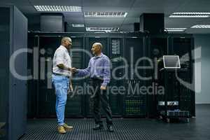 IT support you can trust. two men shaking hands in a data center.
