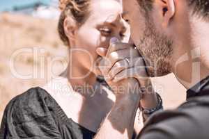 Engagement, love and romance with couple proposal and save the date goal. Closeup of man bonding, holding and kissing womans hands while feeling happy or excited with safety, security and trust ring