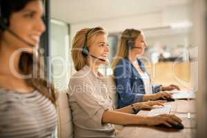 Using all their resources to solve your problems. a group of young women working in a call center.