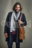 Dare to be well-dressed. Portrait of a stylishly dressed man posing with a leather satchel in the studio.