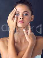 Perfection is never perfect unless you believe it. Studio shot of an attractive young woman posing and touching her face on two different places.