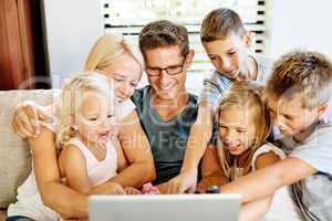 Discovering the wonders of technology together. a family using a laptop together at home.