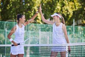 High five, success and celebrating between women tennis players training outdoors on the court. Happy, winning and fit athletes or friends playing in a friendly sports competition team building