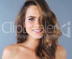 Hair you can hide behind. Studio shot of a beautiful young woman posing against a blue background.