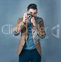 Photography is a great way to demonstrate how creative you are. Studio portrait of a stylishly dressed handsome young man holding a vintage camera.