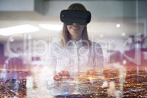 Seeing her business in a brand new light. Multiple exposure shot of a young businesswoman wearing a VR headset while working alone in her office.