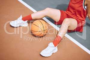 Fitness, sports and woman on basketball court floor for a break after playing a game alone in the summer. Fashion, cool and healthy athlete on the ground after training, wellness and cardio exercise