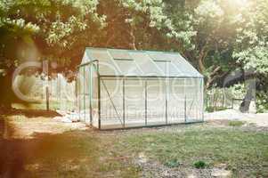 Greenhouse building for sustainability, earth and eco friendly plant growth methods for a garden. Sustainable, ecology and green environmental construction in nature with trees, grass and ground